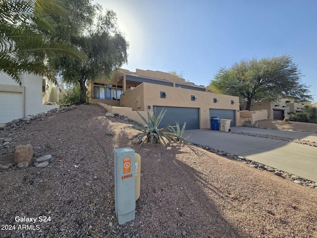 pueblo revival-style home featuring a garage