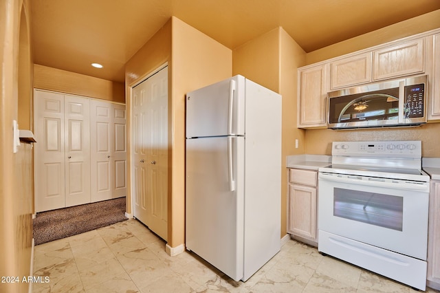 kitchen with light brown cabinetry and white appliances