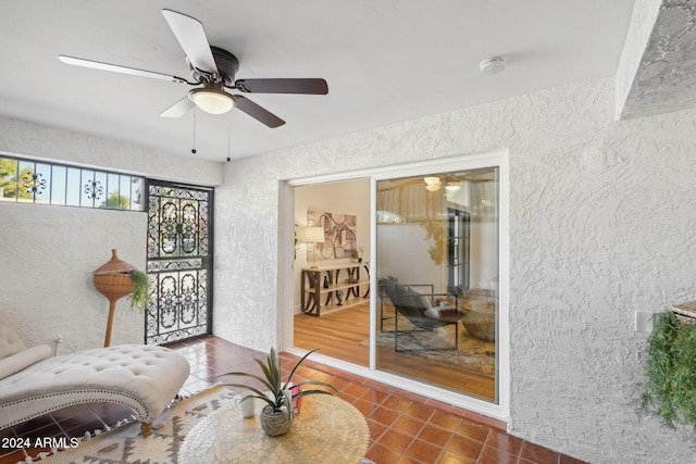 sitting room featuring ceiling fan and dark tile patterned floors