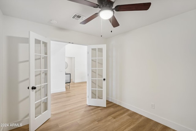 empty room featuring light wood-type flooring, french doors, and ceiling fan