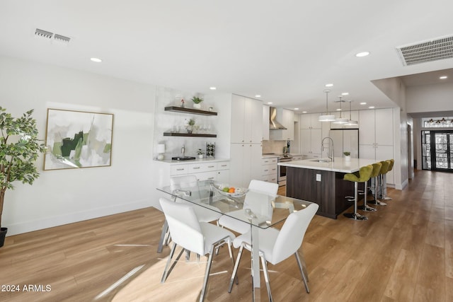 dining space with sink and light wood-type flooring