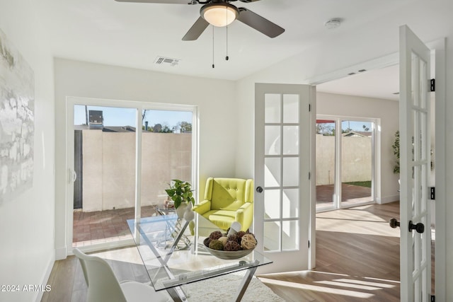 living area featuring a wealth of natural light, ceiling fan, light hardwood / wood-style flooring, and french doors