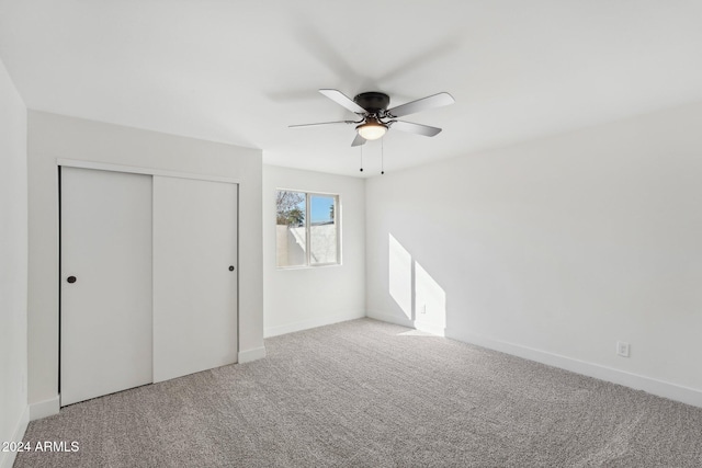 unfurnished bedroom featuring a closet, carpet flooring, and ceiling fan