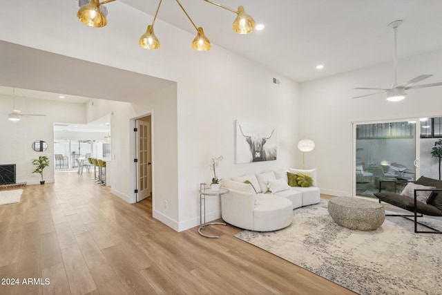 living room featuring high vaulted ceiling, light hardwood / wood-style floors, and ceiling fan