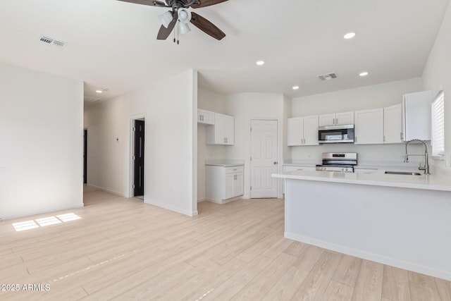 kitchen with light wood finished floors, visible vents, appliances with stainless steel finishes, and a sink