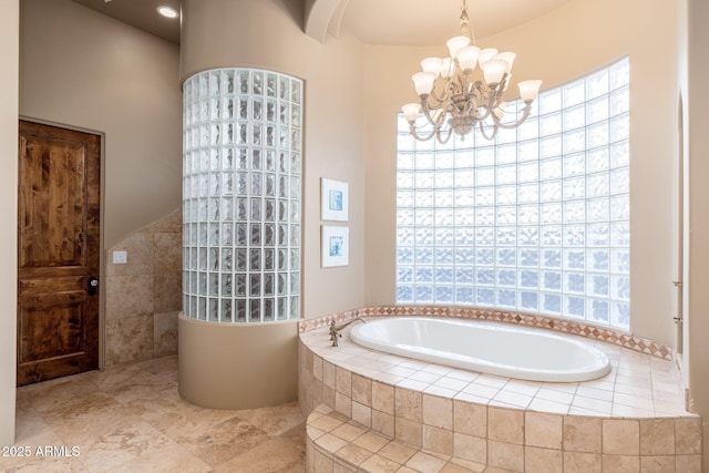 bathroom with a bath, a walk in shower, a notable chandelier, and tile walls