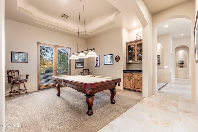 playroom with visible vents, arched walkways, a tray ceiling, billiards, and light colored carpet