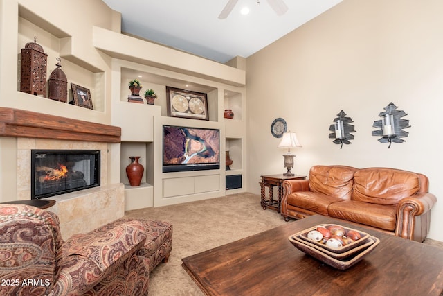 carpeted living area featuring built in shelves, ceiling fan, lofted ceiling, and a fireplace