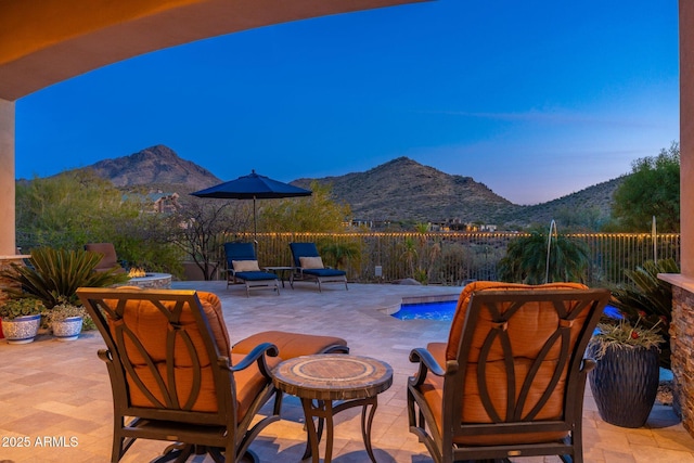 view of patio / terrace featuring a fenced in pool, fence, a mountain view, and an outdoor fire pit