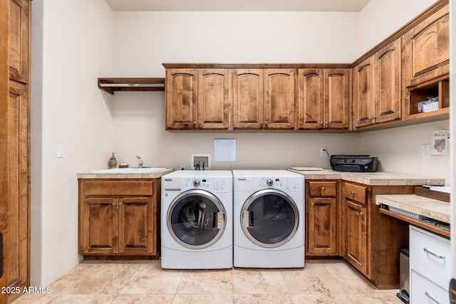 washroom featuring a sink, cabinet space, and washer and dryer