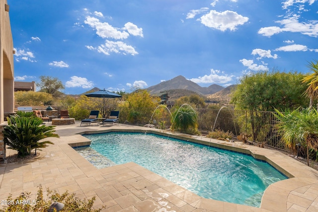 view of swimming pool featuring a mountain view, an outdoor fire pit, a fenced backyard, a patio, and a fenced in pool