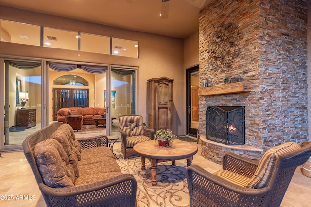 living area with french doors, visible vents, and a stone fireplace