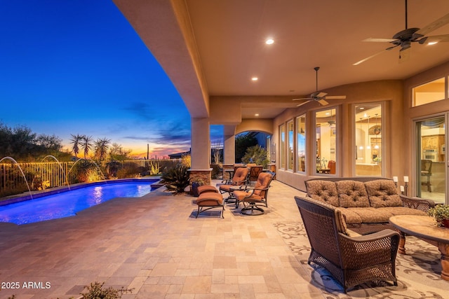 patio terrace at dusk with a fenced backyard, ceiling fan, and a fenced in pool