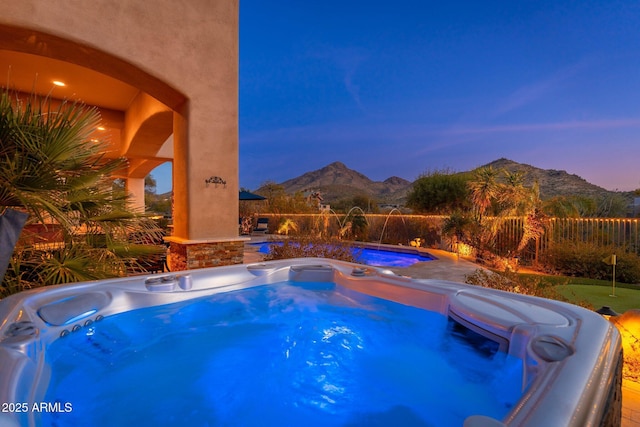 view of pool with a mountain view and a hot tub