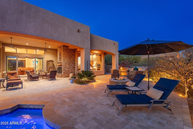 view of patio with area for grilling, an outdoor pool, a ceiling fan, and an outdoor living space with a fire pit