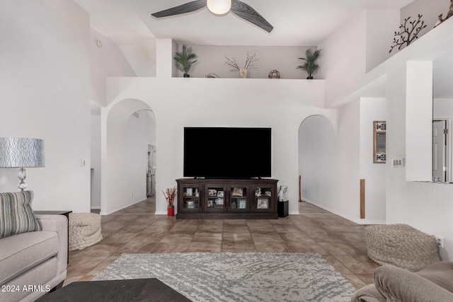 living room featuring ceiling fan and a high ceiling