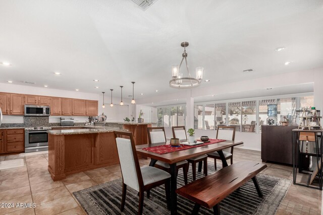 tiled dining space with an inviting chandelier