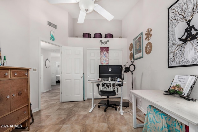 office area featuring a high ceiling, light tile patterned floors, and ceiling fan