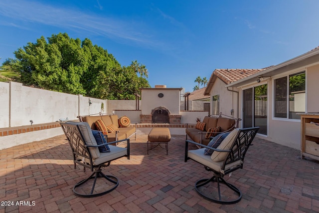 view of patio with an outdoor living space with a fireplace