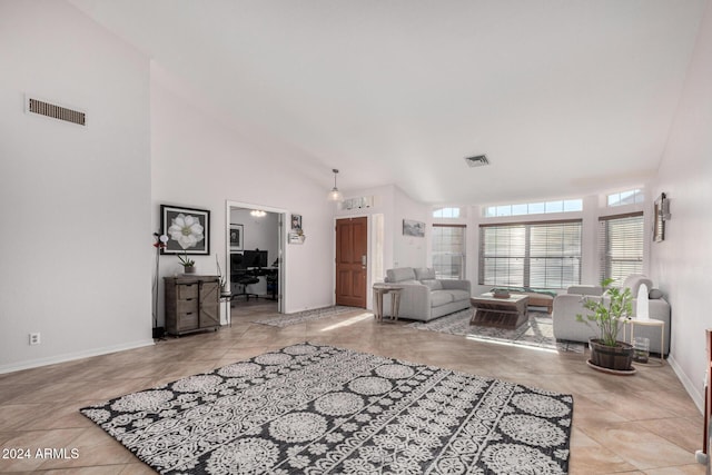 living room with light tile patterned floors and a high ceiling