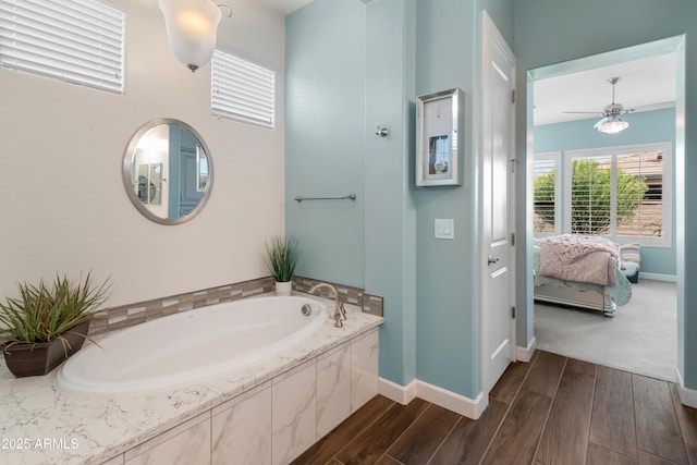 full bath with wood finished floors, a garden tub, baseboards, and ensuite bathroom