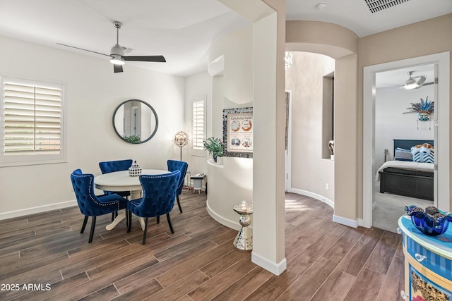 dining room featuring baseboards, ceiling fan, visible vents, and wood finished floors