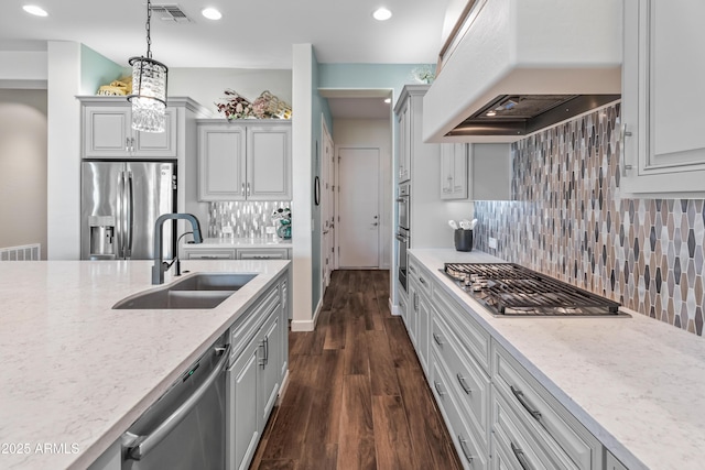 kitchen with stainless steel appliances, a sink, visible vents, dark wood-style floors, and custom range hood