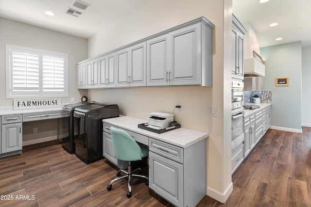 office space with washing machine and clothes dryer, recessed lighting, baseboards, built in study area, and dark wood finished floors