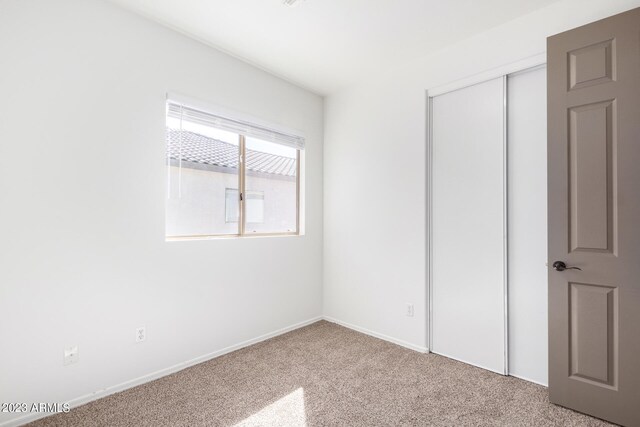 unfurnished bedroom featuring a closet and carpet floors