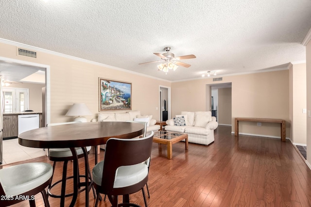 10126 W Sombrero Cir, Sun City, AZ 85373 - dining room featuring ceiling fan, a textured ceiling, wood-type flooring, crown molding, and baseboards