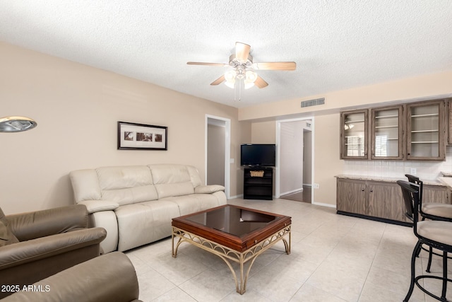 10126 W Sombrero Cir, Sun City, AZ 85373 - living room featuring ceiling fan, a textured ceiling, and light tile patterned flooring