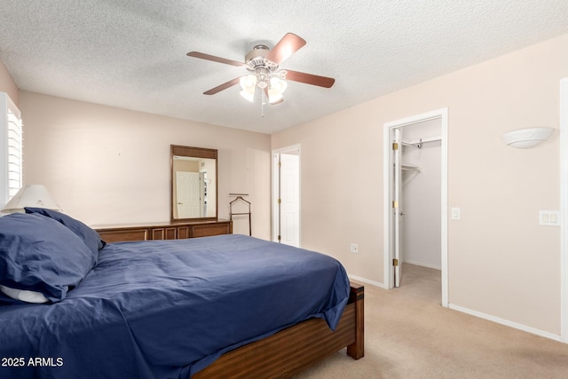 10126 W Sombrero Cir, Sun City, AZ 85373 - bedroom with light carpet, a ceiling fan, baseboards, a walk in closet, and a textured ceiling