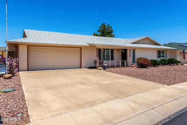 10126 W Sombrero Cir, Sun City, AZ 85373 - ranch-style home featuring brick siding, a porch, an attached garage, and concrete driveway
