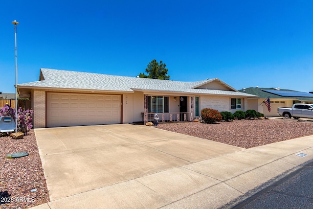 10126 W Sombrero Cir, Sun City, AZ 85373 - ranch-style home featuring covered porch, an attached garage, brick siding, concrete driveway, and roof with shingles