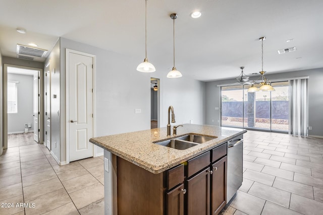 kitchen featuring light tile patterned floors, visible vents, dishwasher, a kitchen island with sink, and a sink