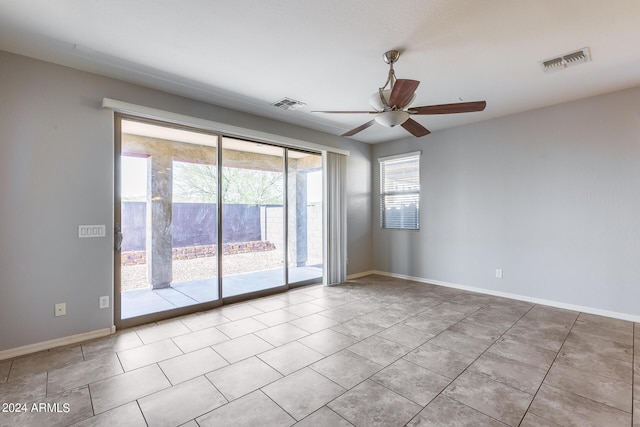 unfurnished room with baseboards, visible vents, and a ceiling fan