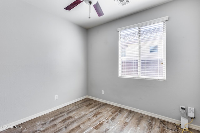 spare room featuring ceiling fan, light wood-style flooring, visible vents, and baseboards