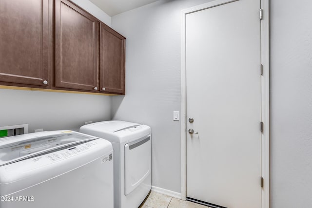 laundry room featuring light tile patterned floors, independent washer and dryer, and cabinet space