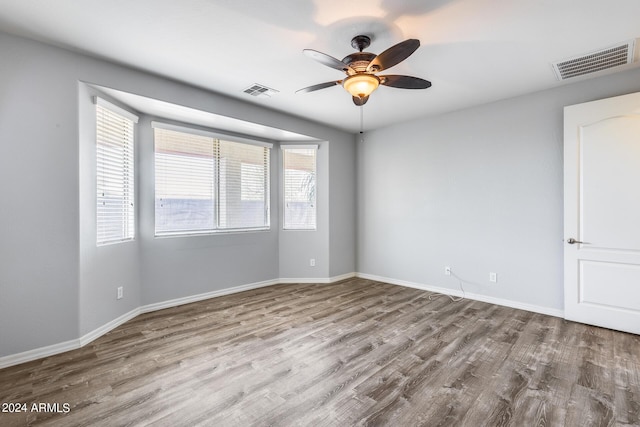 unfurnished room featuring baseboards, visible vents, and light wood finished floors