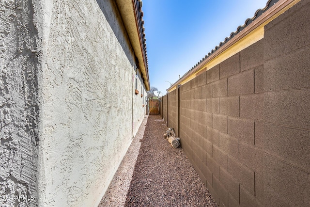 view of side of home featuring fence and stucco siding