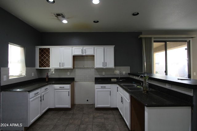 kitchen featuring tasteful backsplash, white cabinetry, plenty of natural light, and sink