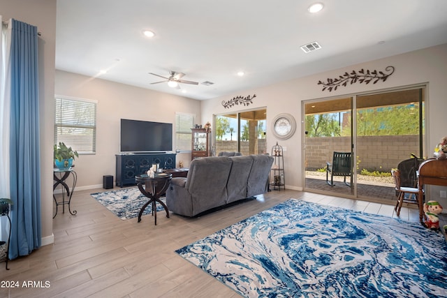 living room featuring ceiling fan and light hardwood / wood-style floors