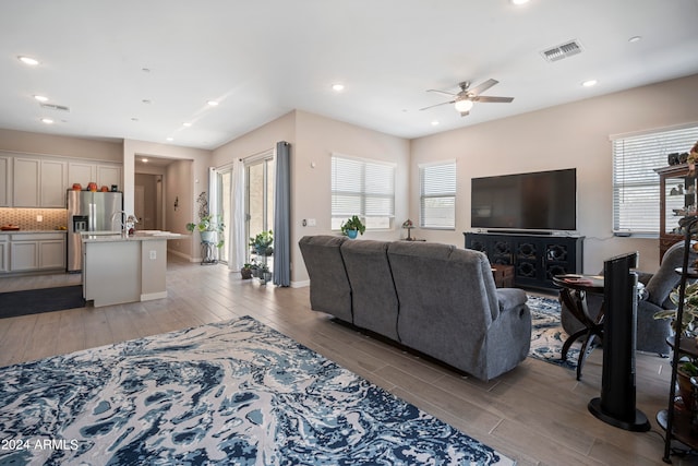 living room featuring ceiling fan and light hardwood / wood-style flooring