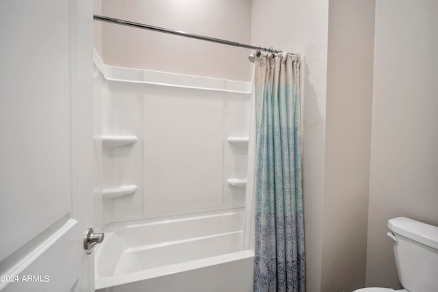 bathroom featuring toilet and shower / tub combo with curtain