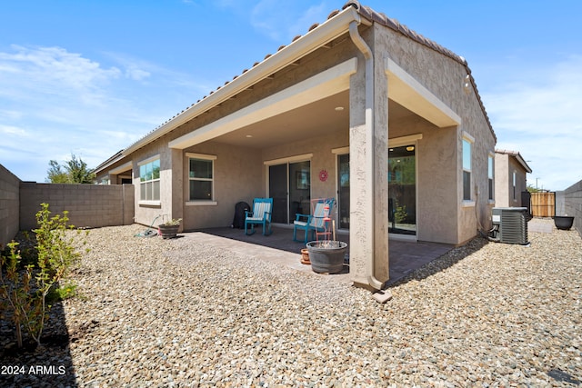 rear view of house featuring central AC unit and a patio