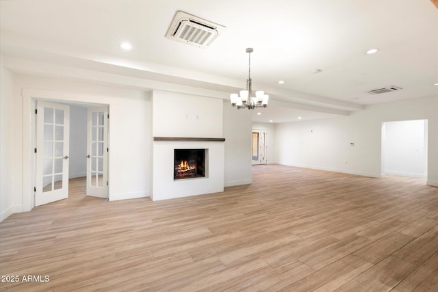 1801 E Berridge Ln, Phoenix, AZ 85016 - unfurnished living room featuring a chandelier, recessed lighting, french doors, light wood-style floors, and a warm lit fireplace