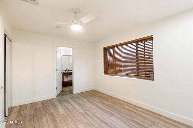 1801 E Berridge Ln, Phoenix, AZ 85016 - unfurnished bedroom with light wood-style floors, baseboards, a closet, ensuite bath, and a ceiling fan
