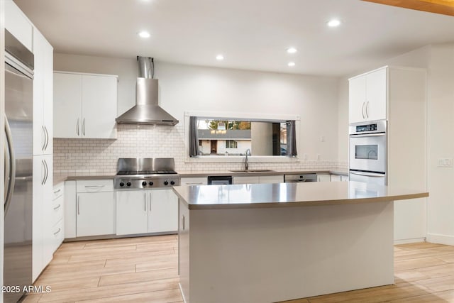 1801 E Berridge Ln, Phoenix, AZ 85016 - kitchen with stainless steel appliances, a sink, wall chimney range hood, light wood-style floors, and tasteful backsplash