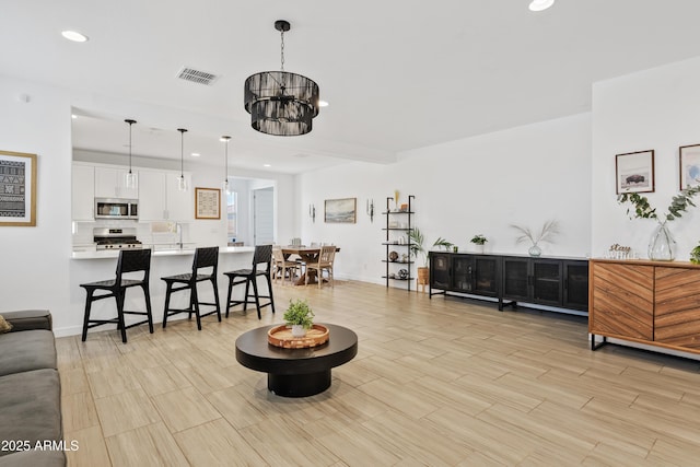 2204 E Kelly Dr, Gilbert, AZ 85298 - living area with a chandelier, wood finish floors, baseboards, visible vents, and recessed lighting