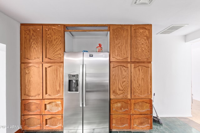 kitchen with dark tile patterned flooring and stainless steel fridge with ice dispenser